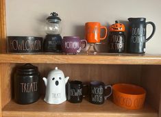 there are many halloween mugs on the shelves in this room, including one that says trick or treat