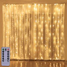 a remote control sitting next to a curtain with lights on it