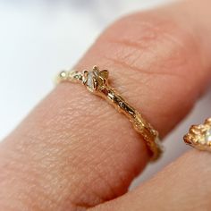 a close up of a person's hand with a gold ring on their finger