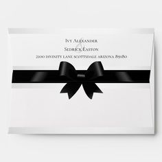 a white envelope with a black bow on the front and back of it's address card