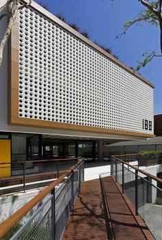 the building is made out of white bricks and has a wooden walkway leading up to it