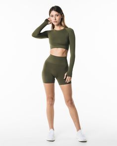 HIGHLIGHTS. Contour lines to enhance the body shape. Crew neckline. Low impact. Long line length LS crop. Raglan cut long sleeve. Form-fitting and cropped cut. Alphalete wordmark logo printed in the back FIT SUGGESTION. This item runs true to Alphalete’s standard seamless fit.. If you are between sizes, we recommend sizing up.. Model is 5’8”/172cm, wearing a size XS with a 31”/78cm bust. MATERIALS AND WASHING DIRECTIONS. 51% Polyamide, 38% Polyester, 11% Elastane. We recommend washing inside-out Versatile Green Top With Seamless Construction, High Stretch Short Length Athleisure Tops, Green Short Workout Tops, Green Short Length Workout Tops, Green Compression Seamless Tops, Fitted Workout Tops Short Length, Elastane Workout Tops Short Length, Seamless Stretch Top With Short Length, Contour Lines