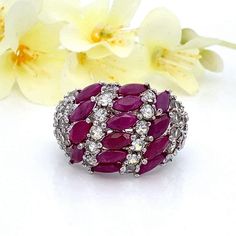 This sterling silver dome cluster ring features genuine ruby marquise gemstones and round white cubic zirconia. This gives a big look! Size 7 Metal Content: 925 Sterling Silver Face Height (North/South): 17mm Rise Above Finger: 7 mm Band / Shank Width: 3mm Gemstones:  14 Marquise Shaped Genuine Rubies - 6mm x 2.8mm Round Cubic Zirconia Weight: 7.60 Grams Stamps: R 925 China Condition: Excellent Pre-Owned  Each piece is thoroughly examined and refinished as needed by our professional jewelers, tested to guarantee metal content,  graded by our in-house GIA (Gemological Institute of America) Graduate Gemologist, and inspected for quality before being carefully packaged and promptly shipped. Thank you for taking the time to shop with us! We have hundreds of more listings, with more being added Diamond White Multi-stone Marquise Rings, Diamond White Marquise Multi-stone Ring, Cubic Zirconia Marquise-cut Multi-stone Diamond Ring, Multi-stone Cubic Zirconia Marquise Cut Ring, Marquise Cut Multi-stone Cubic Zirconia Diamond Ring, White Gold Ruby Multi-stone Diamond Ring, White Gold Ruby Diamond Ring With Multi-stone, Marquise Multi-stone Cubic Zirconia Rings, Marquise Cubic Zirconia Multi-stone Rings