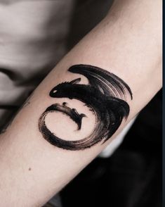 a man with a tattoo on his arm that has a black dragon in the middle