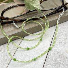 Shiny and bohemian eyeglass necklace chain in green tones with light flashes of gold, made with Preciosa Czech crystal seed beads and tiny green Jade gemstones.     Paired with beautiful silver plated crystal seed beads, this handmade eyeglass chain will definitely create a unique look. This eyeglass lanyard is made on strong quality beading wire with wire guardians that protect the quality eyeglass holder grips. The necklace is ended with spring clasps that hold the eyeglass grips and they can Glasses Lanyard, Eyeglass Necklace, Grandma Necklace, Sunglasses Holder, Mask Holder, Sunglass Chain, Sunglass Holder, Eyeglass Chain, Eyeglass Holder