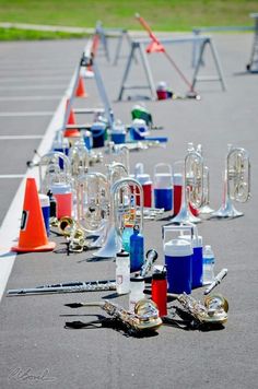 an array of musical instruments are lined up in a parking lot next to cones and traffic cones