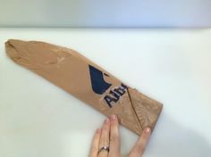 a person is holding up a piece of cardboard with the word alila on it