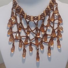 This beautiful fully beaded choker style waterfall necklace is cascading with amber and bronze colored beads falling down with a 5" drop on a 13.5 inch beaded crown.  It is hallmarked SJH on the tag.  Beautiful! Beaded Teardrop Brown Necklace, Brown Beaded Teardrop Necklace, Brown Bead Caps For Jewelry Making, Waterfall Necklace, Beaded Crown, Choker Style, Vintage Crystal, Beaded Choker, Falling Down