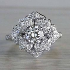 a white gold ring with diamonds in the center on a wooden table, close up