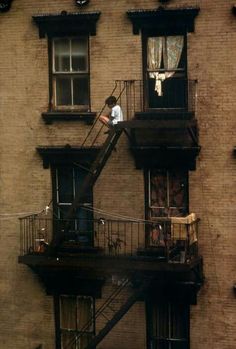 a man is standing on the balcony of an apartment building in new york city, ny