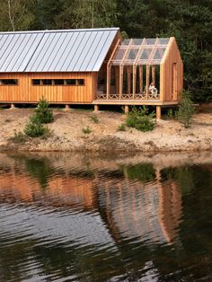 a wooden cabin sitting on top of a lake next to a forest