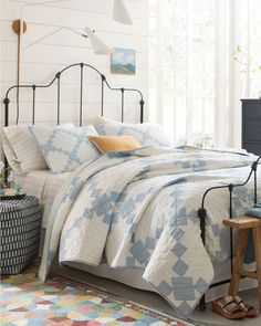 a bed with blue and white quilts in a bedroom