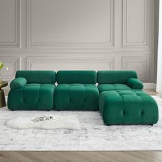 a green couch sitting on top of a white rug