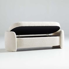 a white couch with a black pillow on it's backrest and seat cushion