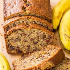 sliced banana bread on a cutting board next to some bananas and two other fruit pieces