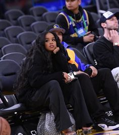 two people sitting in the stands at a basketball game