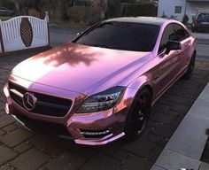 a pink car parked in front of a house