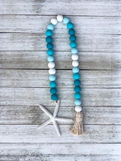 a blue and white beaded necklace with a starfish charm on top of it