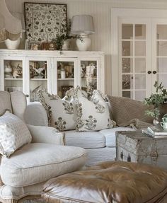 a living room filled with lots of furniture next to a white cabinet and window sill