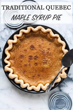 a pie sitting on top of a table next to canisters and a spoon