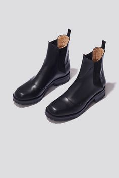 The Nerea boot is a Chelsea boot with a chunky silhouette built on a leather and rubber outsole for comfort and traction. This season we’re introducing a version of the Nerea Boot with a higher shaft that hits above the ankle for even more coverage from the cold. Crafted from soft and supple black vegetable tanned leather, the Nerea boot is detailed with elasticized sides, unconventional seaming and a grosgrain pull tab at the back. We’ve sourced the lug soles from Febo, a rubber brand renowned Tailored Pants, Chelsea Boot, Pull Tab, Vegetable Tanned Leather, Low Heels, Chunky Knit, Leather Heels, Tan Leather, Chelsea Boots