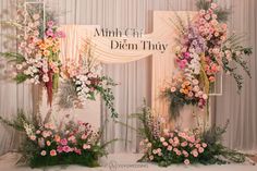 two floral arrangements on display in front of a backdrop with the words, amnh chi diem thay