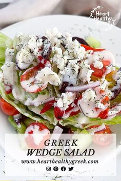 a salad with tomatoes, lettuce and feta cheese is on a white plate