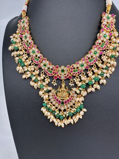 Jadau Kundan Goddess Lakshmi Short Neckline Necklace with Emerald Beads with matching JhumkasColor : GoldenSize : Necklae Length : 14 Inches; No EarringsStones : Jadau Kundan Red Green Clear Jadau Kundan Emerald Beads Emerald Beads Necklace, Necklace For Neckline, Emerald Bead, Goddess Lakshmi, Social Events, Indian Jewelry, Red Green, Emerald, Beaded Necklace