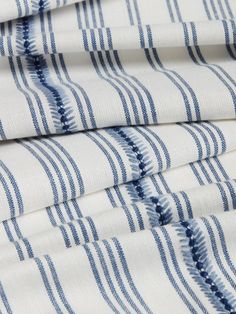 the blue and white striped fabric is folded on top of each other, with vertical stripes