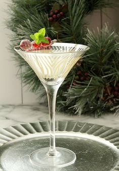 a martini glass filled with fruit and garnish on top of a silver tray