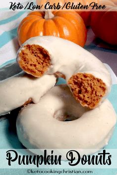 pumpkin donuts with white glaze and cinnamon roll holes on top, sitting on a blue plate