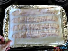 bacon wrapped in tin foil on top of an oven