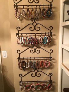 there is a rack with many pairs of bracelets hanging from it's sides