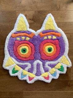 a purple and orange cat shaped rug sitting on top of a wooden floor