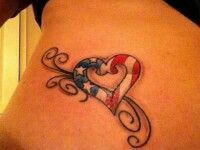 a woman's stomach with an american flag heart tattoo