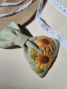 two hats with sunflowers on them are laying next to each other and one has a bow tie