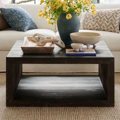 a living room with a couch, table and flowers in the vase on the coffee table