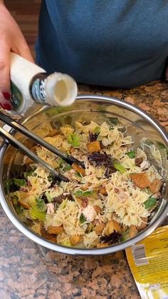 someone is mixing food in a bowl with chopsticks