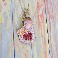 a keychain with the word mom on it and a cupcake in the middle