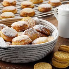 a basket filled with sugar covered donuts next to cookies