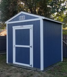 a blue and white shed sitting in the grass