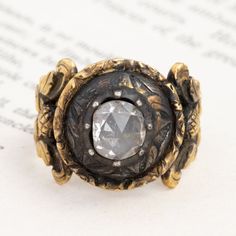 By far one of the most unique antique rings we’ve come across lately! A true antiquity, and covered in delicious patine with a charming Georgian rose cut diamond (with a super high dome!) sitting front and center. We find everything about this piece to be so captivating - from the carved details along the whole ring to the way it feels when worn. 18kt yellow gold Size 8.25 and slightly resizable with limitations Diamond Is K color, SI2 clarity, and GIA standards Please see qualitative report for Victorian Oval Engraved Ring With Rose Cut Diamonds, Antique Oval Engraved Ring With Rose Cut Diamonds, Victorian Engraved Ring With Rose Cut Diamonds, Antique Cluster Ring With Rose Cut Diamonds, Heirloom Dome Ring With Rose Cut Diamonds, Heirloom Oval Dome Ring With Rose Cut Diamonds, Antique Engraved Diamond Ring With Rose Cut, Antique Diamond Signet Ring With Rose Cut, Antique Diamond Signet Ring With Rose Cut Diamonds