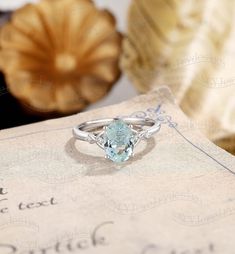 a ring with a blue topaz sits on a piece of paper