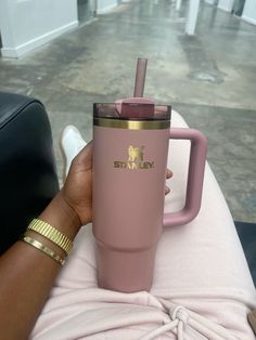 a person holding a pink starbucks cup with a straw in it