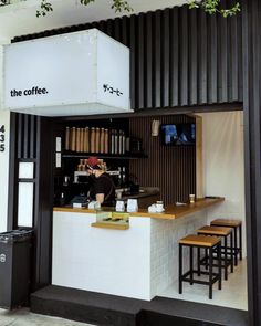 the coffee shop has two stools at the counter and is decorated in black and white