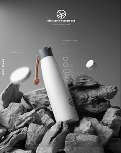 a white and black water bottle sitting on top of rocks next to a pile of rocks