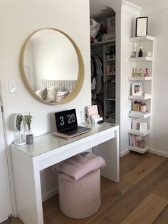 a white desk with a mirror on the wall