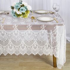 the table is set with plates, silverware and blue flowers on top of it