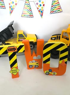 there are construction vehicles and signs on the table for children's birthday party decorations