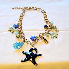 Fashion Goldtone 16" With 3" Extender Beach Wear Necklace With Glass Beads, Sea Horse, Dolphin, Coral, And Blue Starfish Charms. Never Worn Blue Strand Necklaces For Beach Season, Blue Necklaces For Summer Beach, Blue Necklace For Summer Vacation, Blue Necklace For Beach Season, Blue Beaded Necklaces For Beach Season, Blue Ocean-inspired Jewelry For Vacation, Blue Starfish Charm Jewelry For The Beach, Blue Starfish Charm Jewelry For Summer, Adjustable Blue Necklace With Starfish Charm